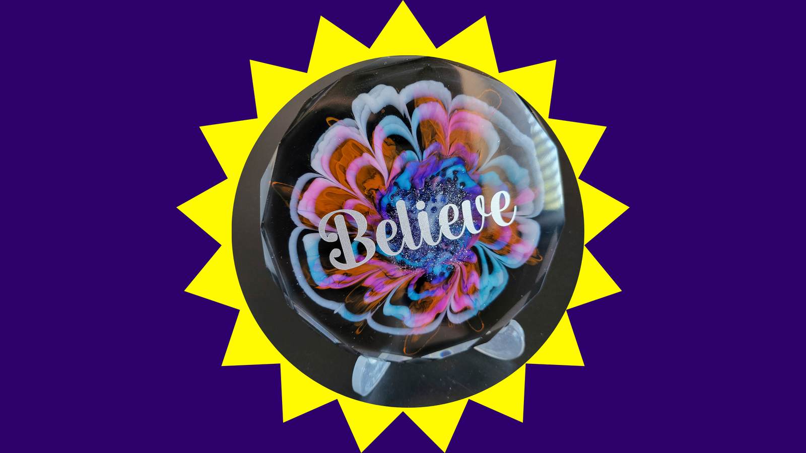 Brand Purple background. Brand yellow multi-star shape with image in the centre of a coaster with a bloom and a decal saying believe