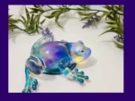 Aurora-shimmer resin frog displayed with green leaves and lavender accents.