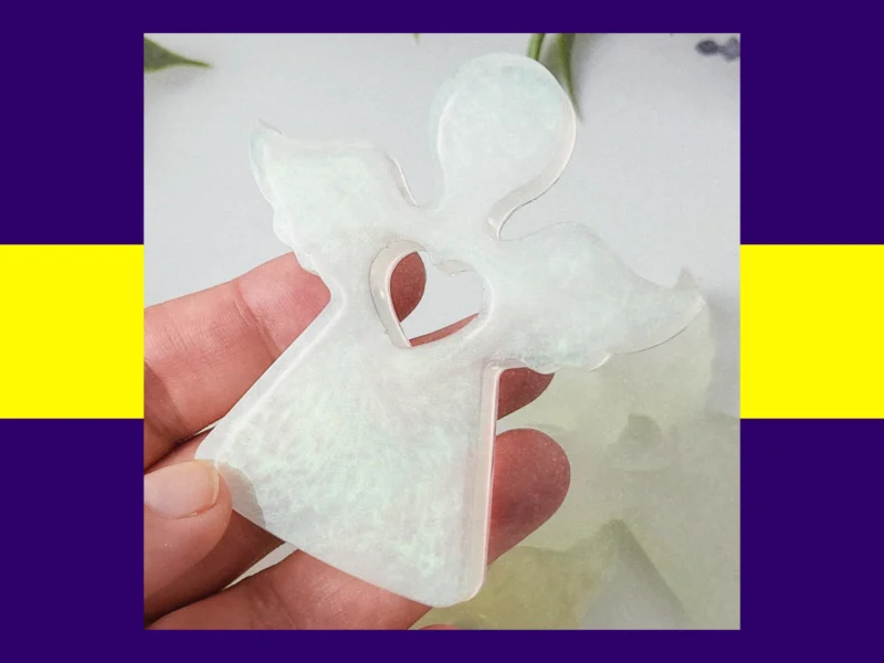 Hand holding a resin Guardian Angel in the blue shimmering colour variant.