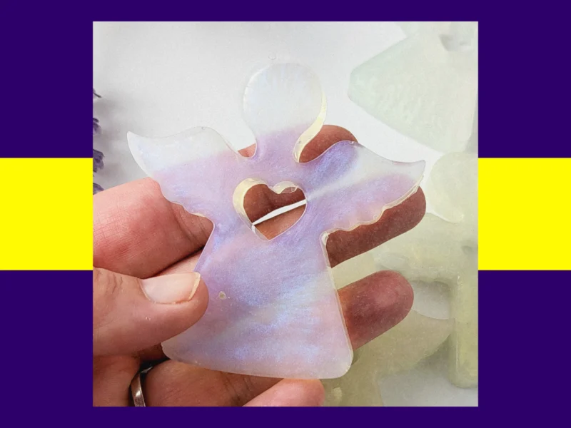 Hand holding a resin Guardian Angel in the violet iridescent colour variant.