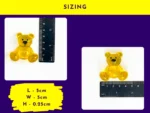Yellow resin handheld Worry Bear next to ruler with size guide 5 cm by 5 cm, flat pocket pal dimension