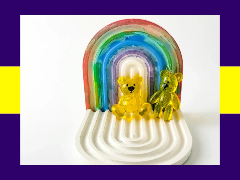 Yellow resin Worry Bear handheld and keyring pair displayed on white rainbow arch tray – bright pocket comfort bears