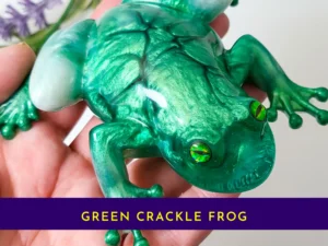 “Handheld view of the OOAK green crackle resin frog showing detailed crackle texture and glossy finish.”