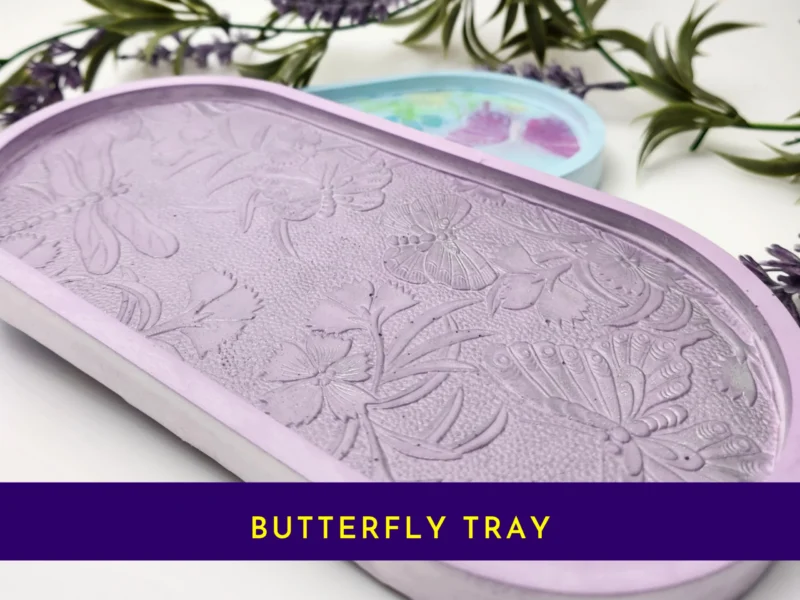“Front view of pastel resin trinket tray featuring raised dragonflies, butterflies and floral details.”