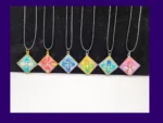 Six one-of-one square resin pendant necklaces lined up on cords, showing different colour designs.