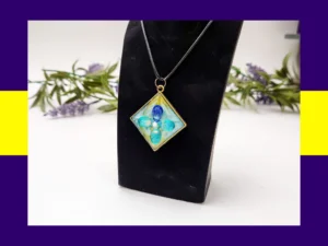 Teal square resin petal pendant necklace displayed on a black jewellery stand