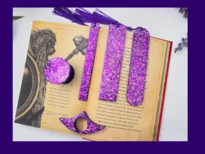 Purple glitter bookmark set laid out on an open book showing all five styles together.