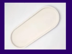 Angled top view of the white oval tray on a light background, showing the raised rim and smooth interior.