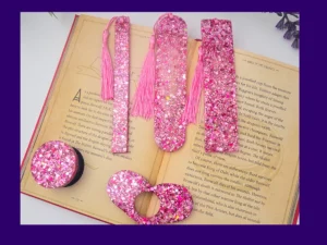 Pink glitter bookmark set laid out on an open book (all five styles visible).